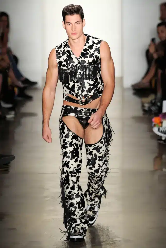 A man in animal print clothing walks down the runway.