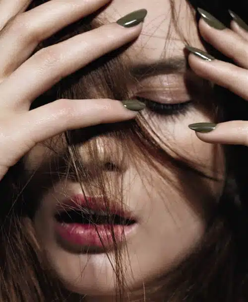 A woman with her hands covering her face.
