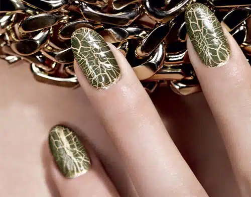 A woman is holding her nails with gold foil.