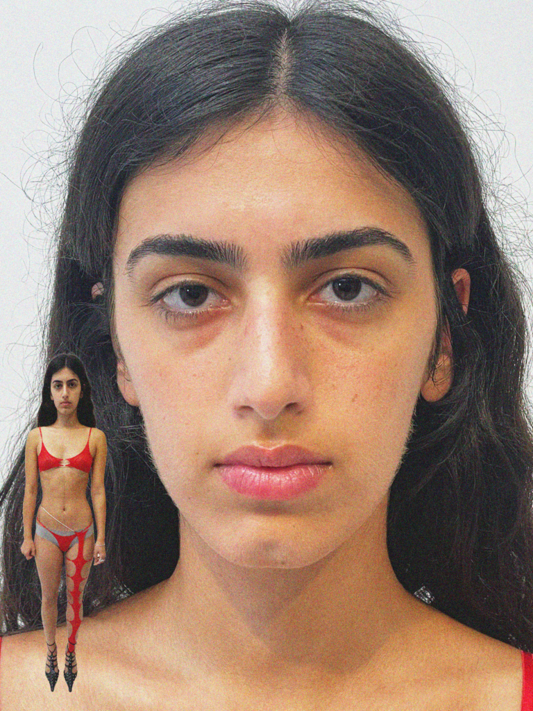 A woman with long hair and no makeup in front of a doll.