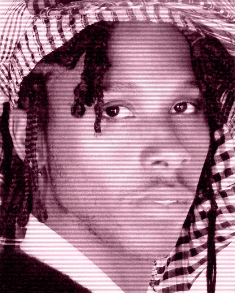 A man with dreadlocks and a checkered headscarf.