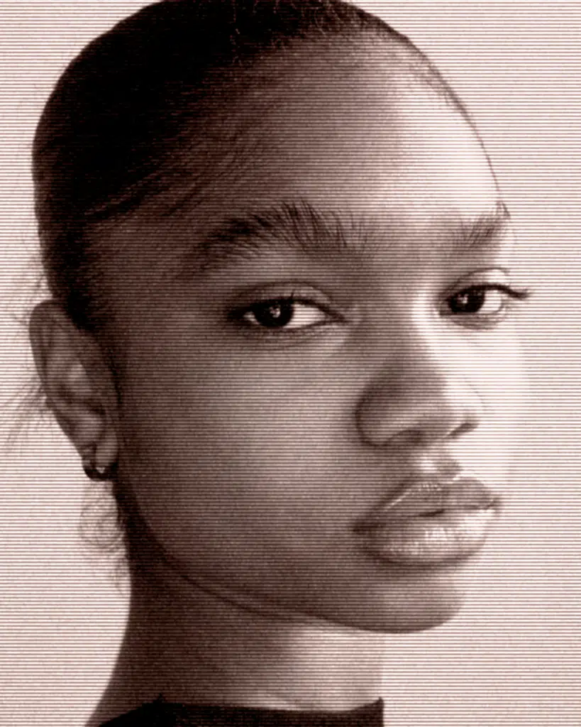 A young woman with a piercing is looking at the camera.