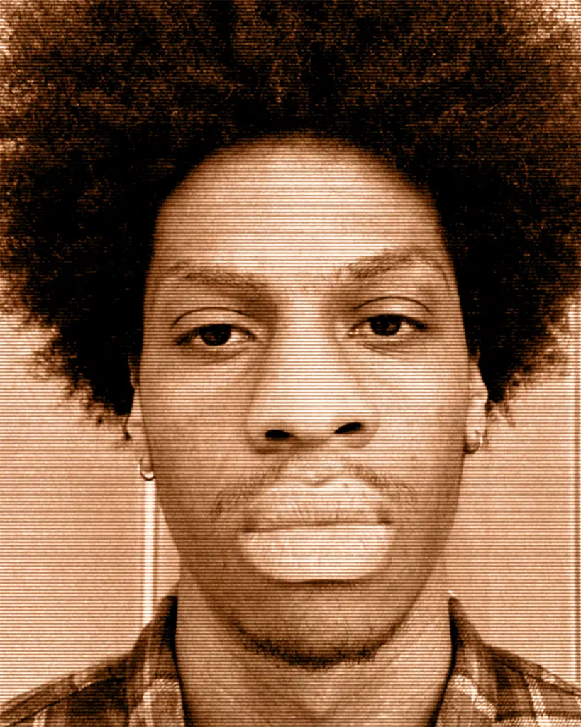 A man with a very large afro is looking at the camera.