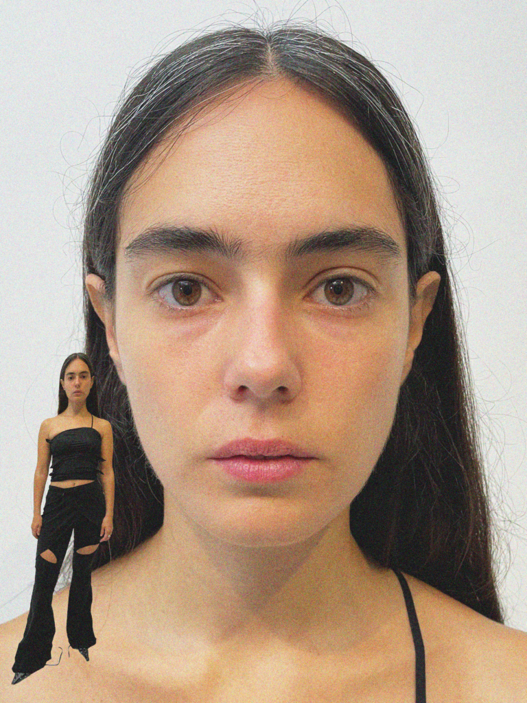 A woman with long hair and no makeup is standing next to a doll.