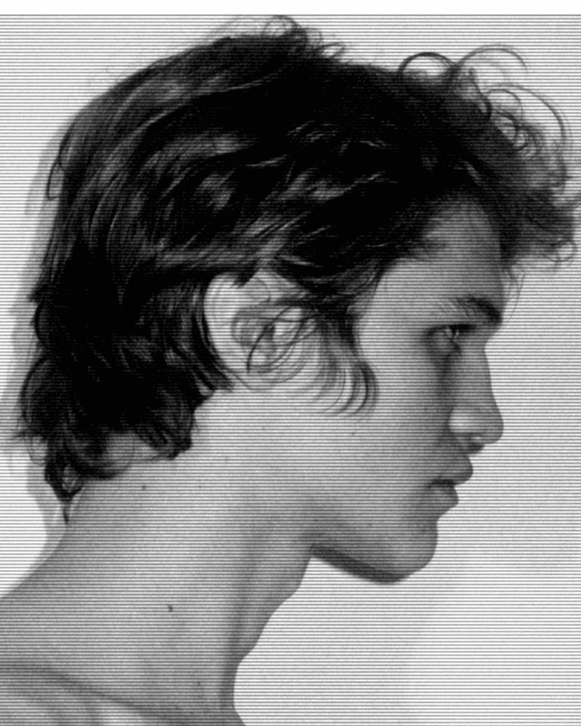 A young man with long hair is looking to his left.