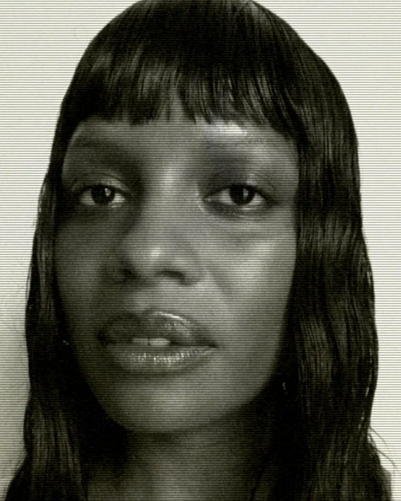 A black and white photo of a woman with bangs.