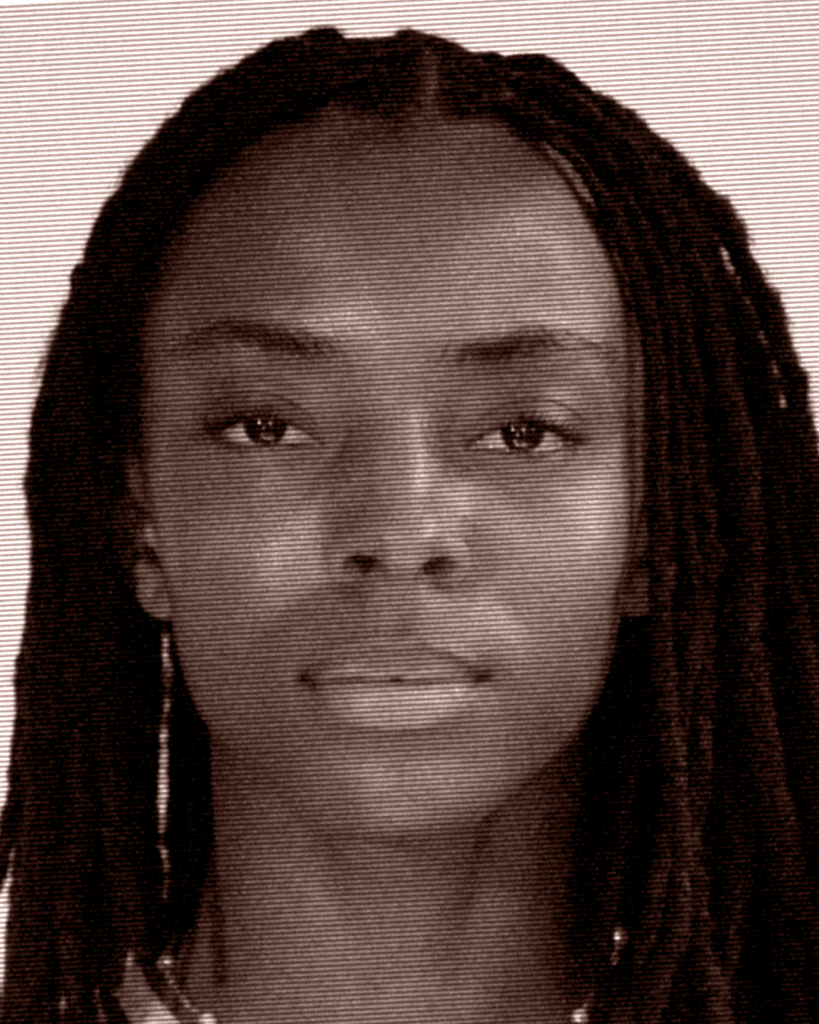 A black woman with long hair and no makeup.