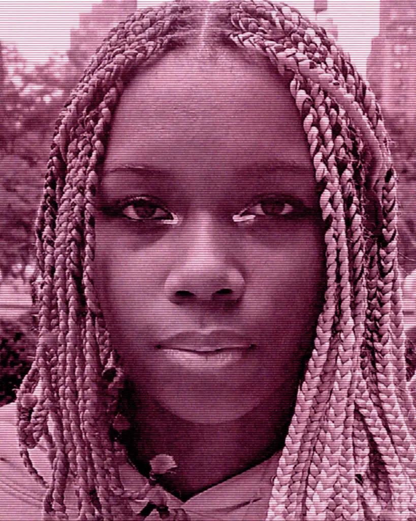 A woman with braids is looking at the camera.