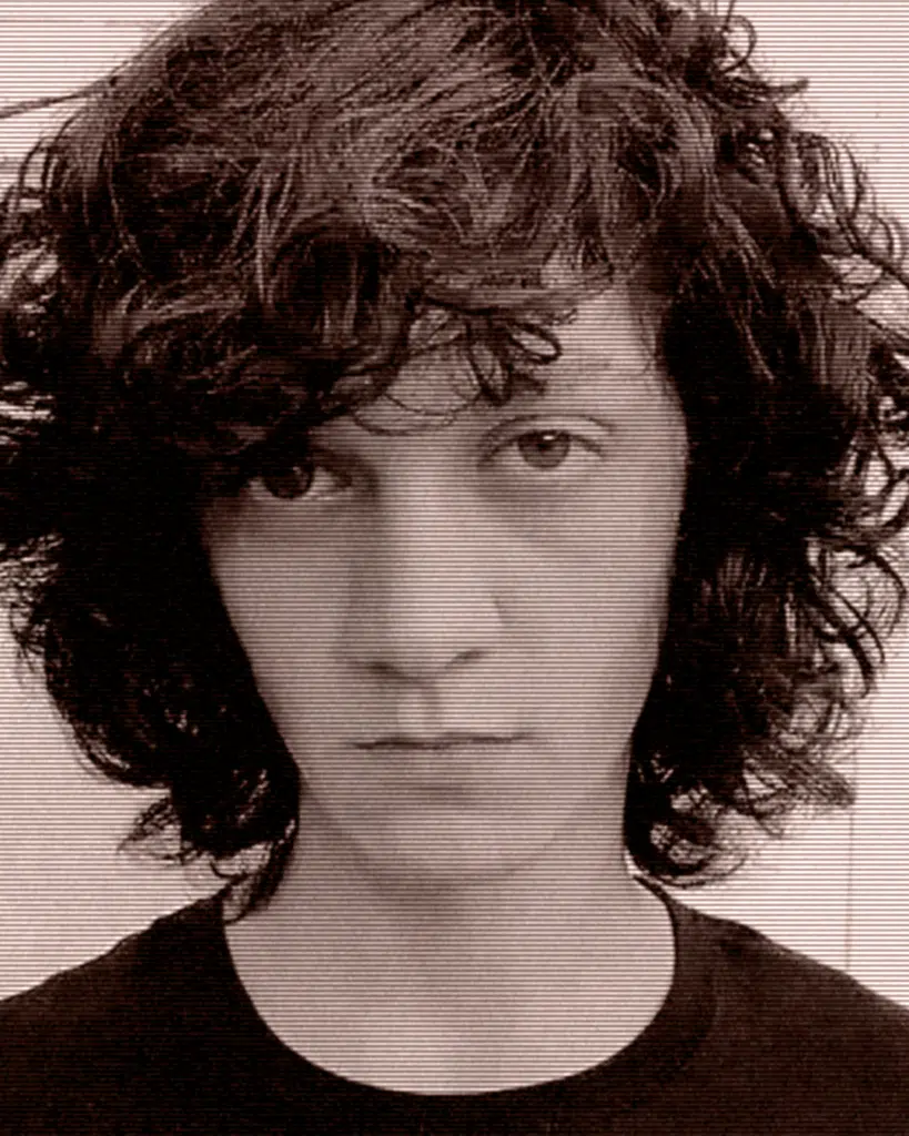 A person with curly hair and a black shirt