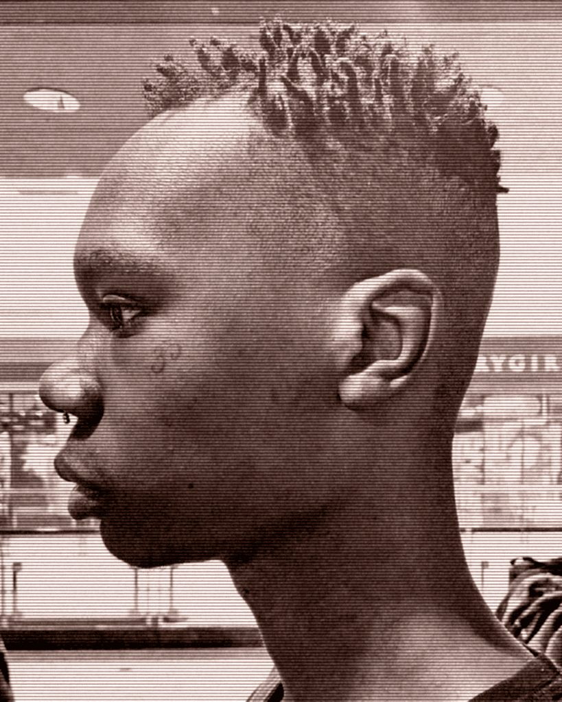 A young man with a mohawk haircut in front of a store.