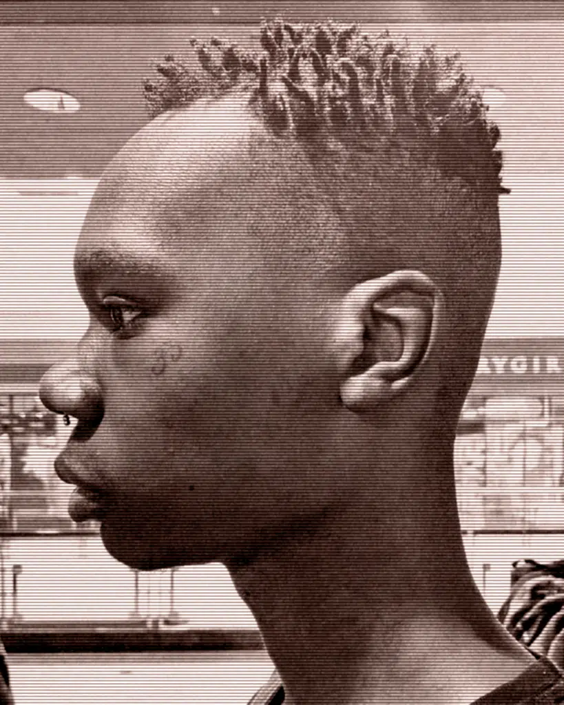 A young man with a mohawk haircut in front of a store.