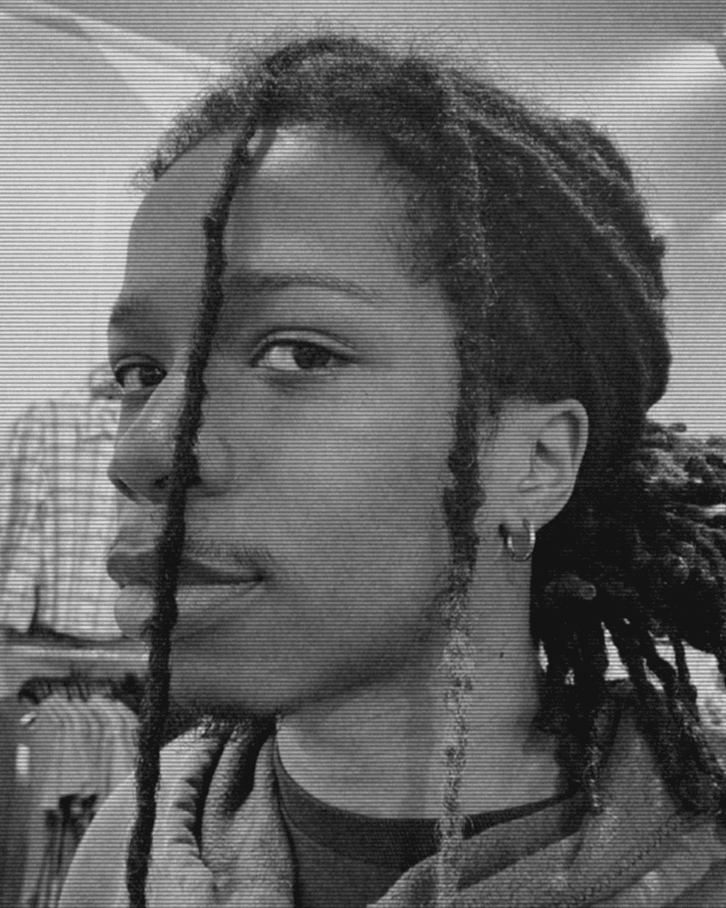 A black and white photo of a person with dreads.