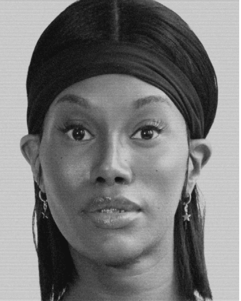 A black and white photo of a woman with a turban.