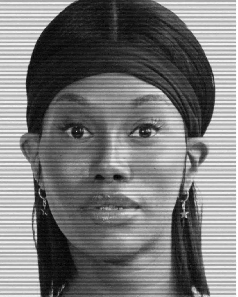 A black and white photo of a woman with a turban.