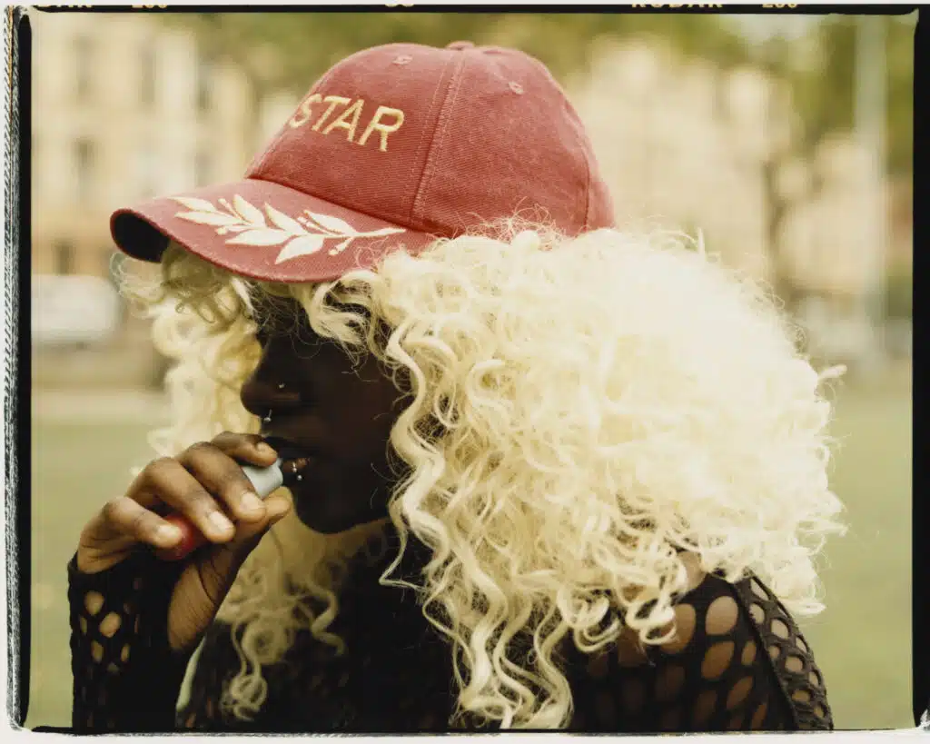 A woman with curly hair wearing a red hat.