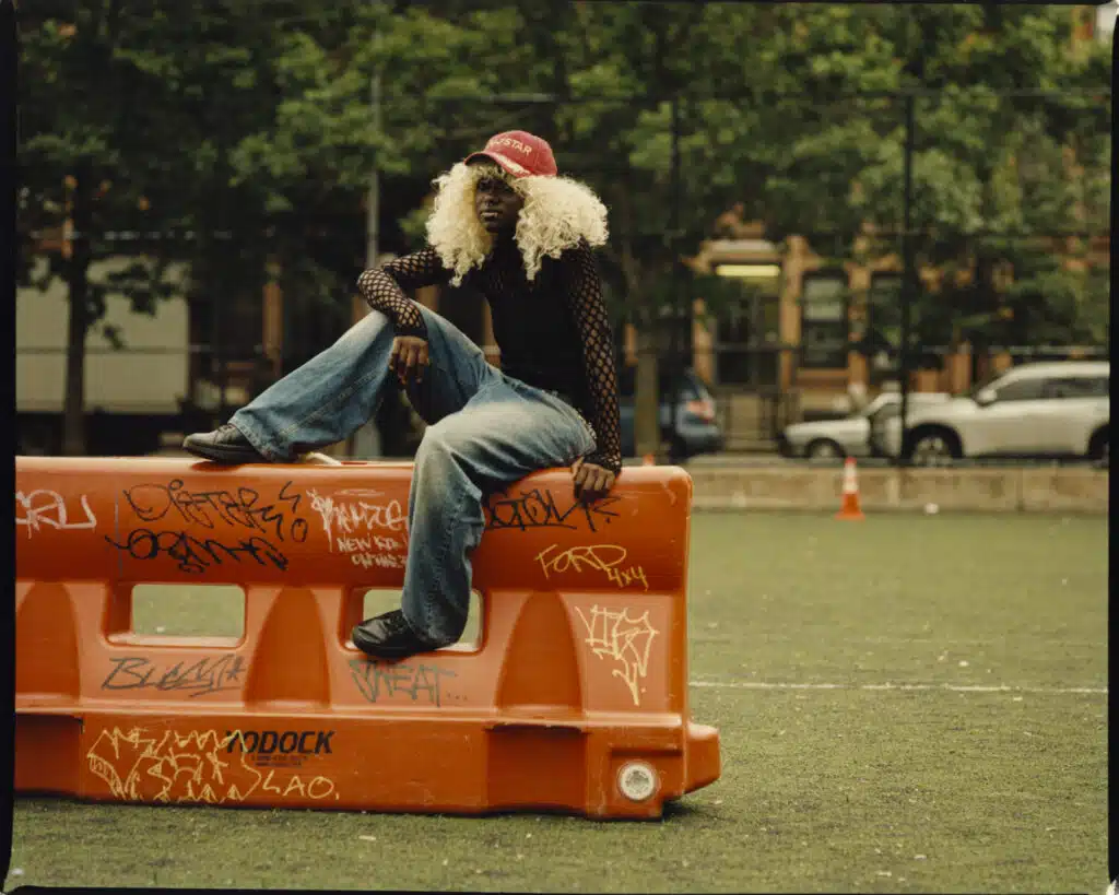 A man sitting on top of an orange object.