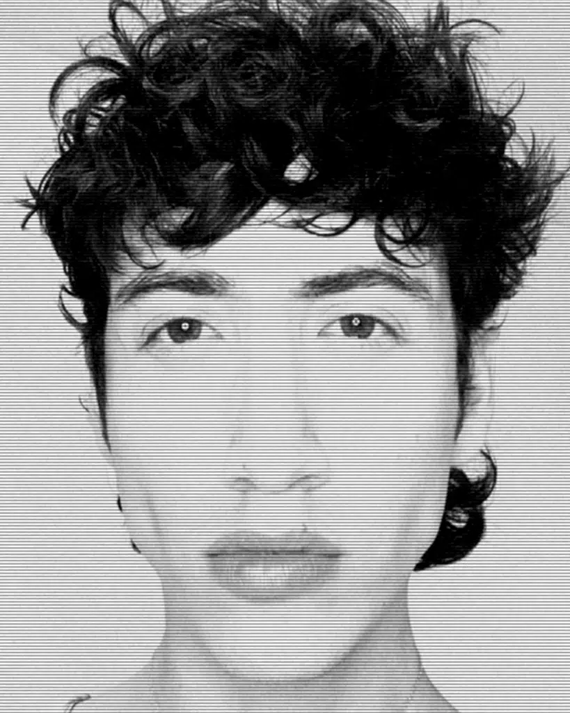 A man with curly hair and wearing earrings.