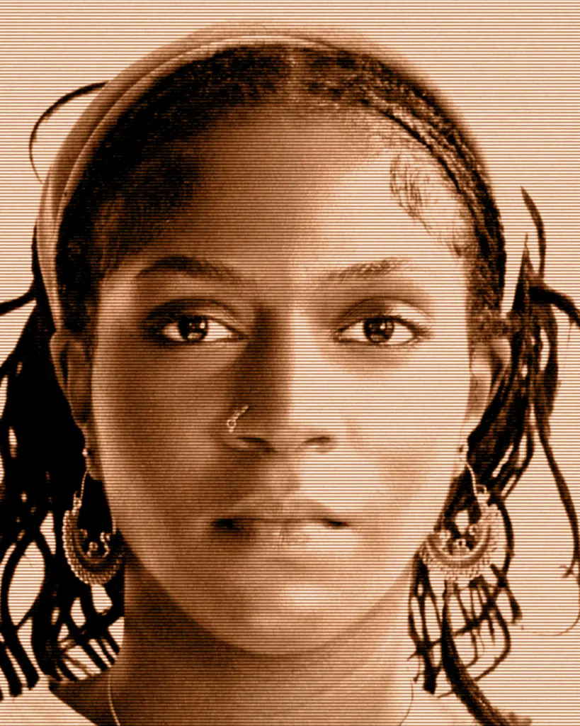 A woman with dreadlocks and large earrings.