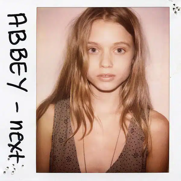 A young girl with long hair and a brown shirt.