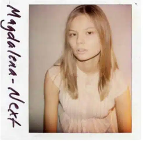 A polaroid picture of a young girl with long hair.