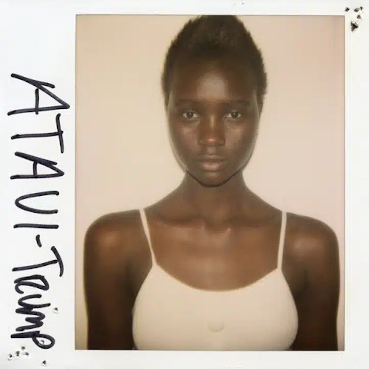 A polaroid picture of a woman with her hair in the air.