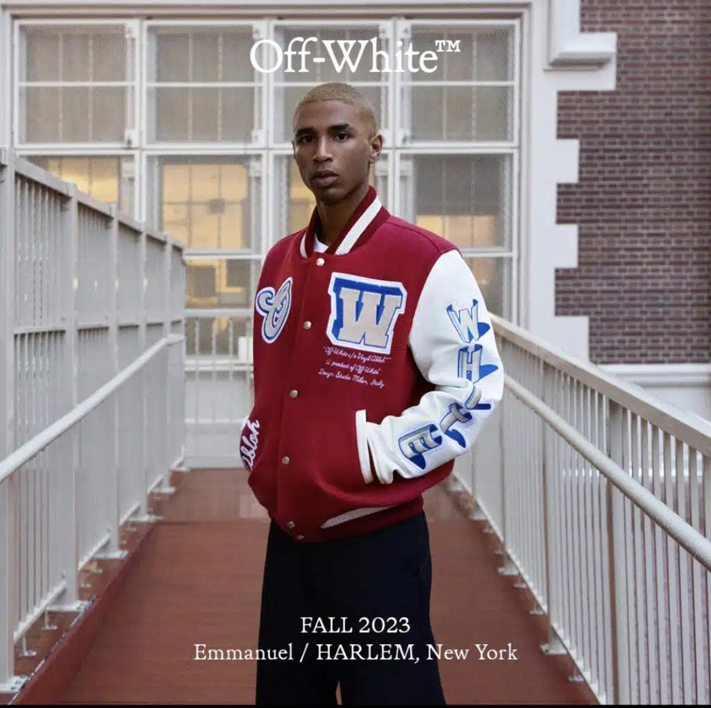 A man in a red and white jacket standing on the stairs.