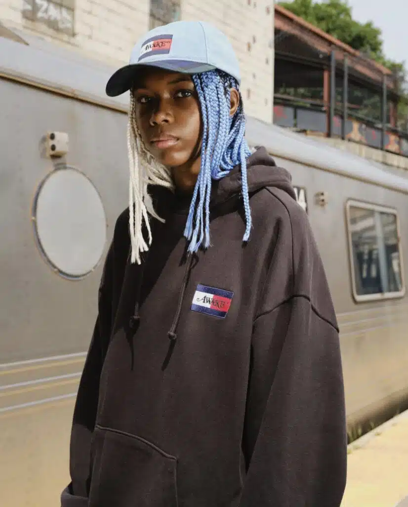 A man with long white hair wearing a hat.