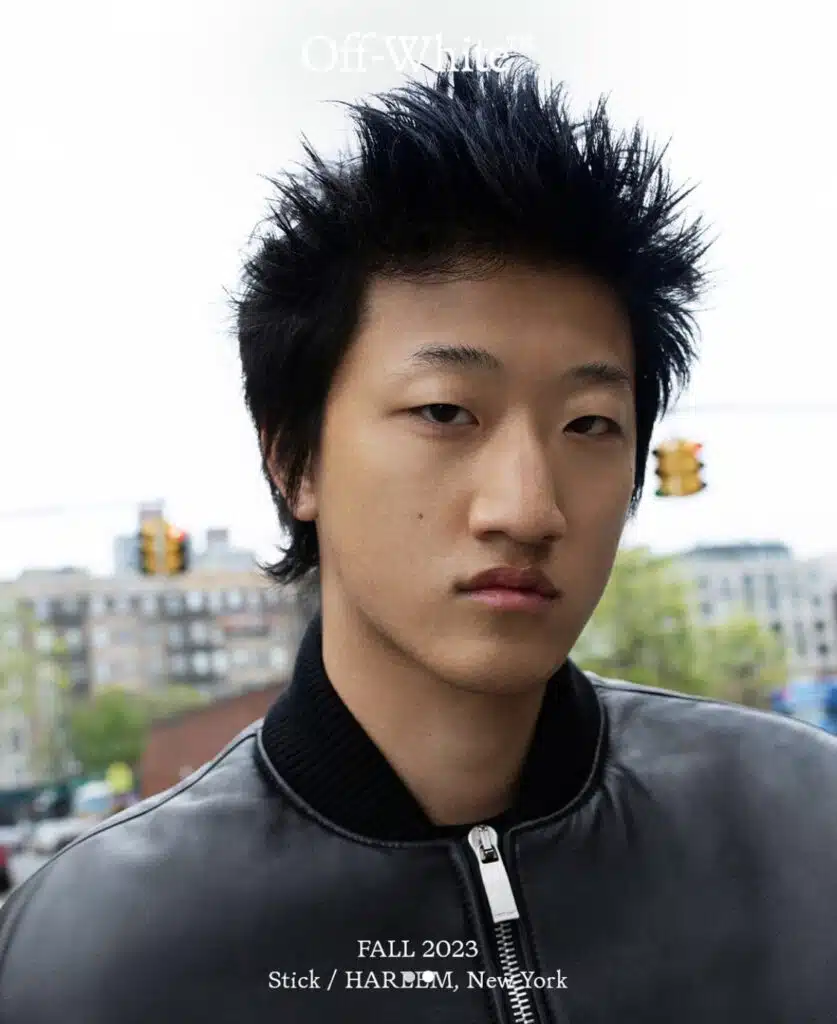 A young man with spiky hair and wearing a jacket.