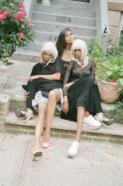 Three women sitting on steps with white hair.