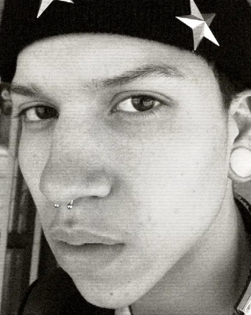 A man with a hat and nose ring.