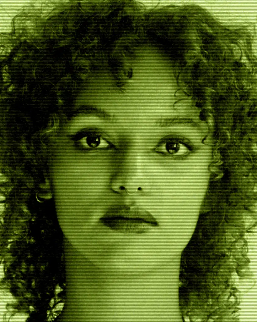 A woman with curly hair and tears in her eyes.