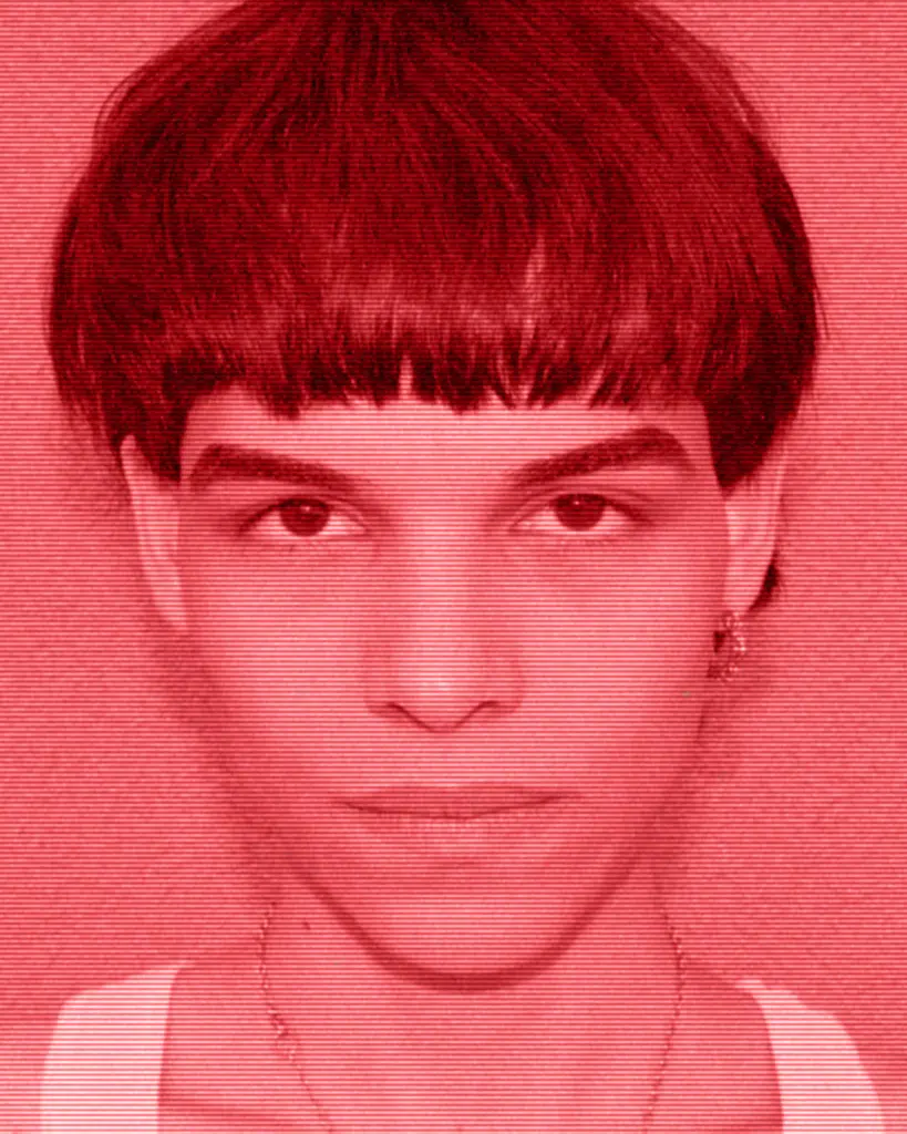 A young man with short hair and a red background