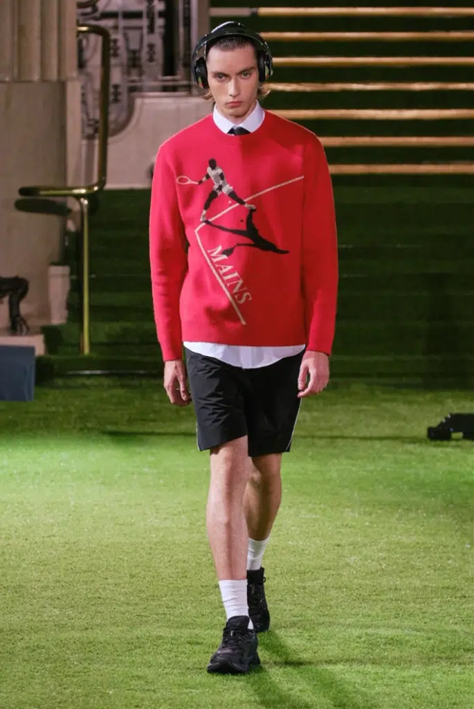 A man in red sweater and black shorts.