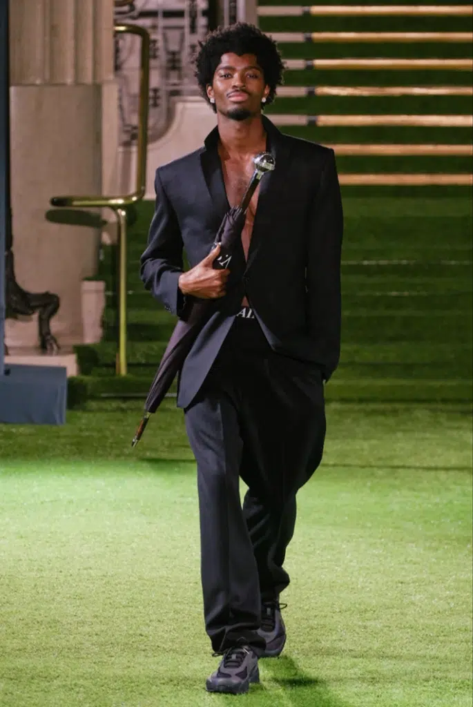 A man in suit and tie holding an umbrella.