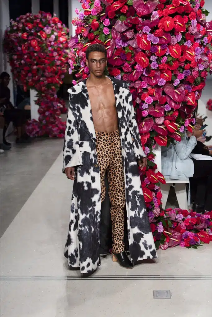 A man in animal print pants and a cow coat.