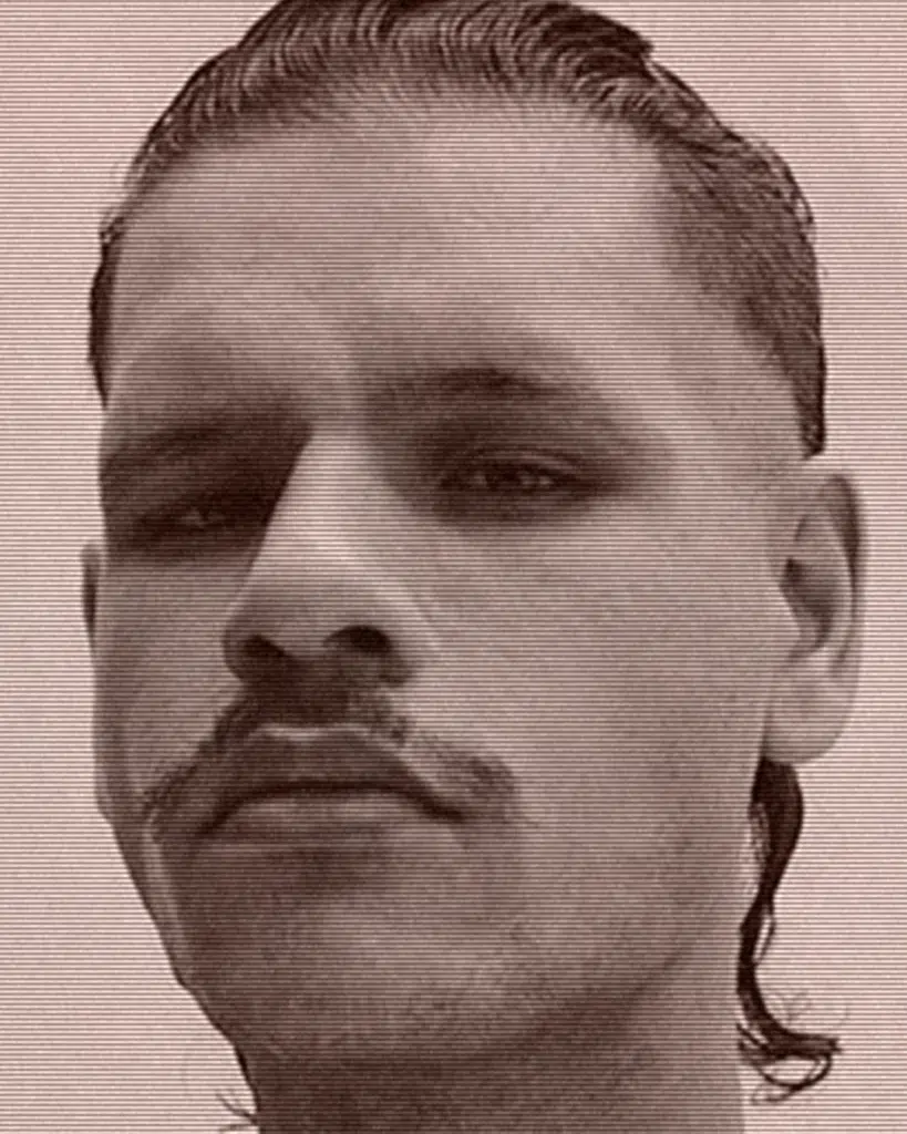 A man with a mustache and long hair.