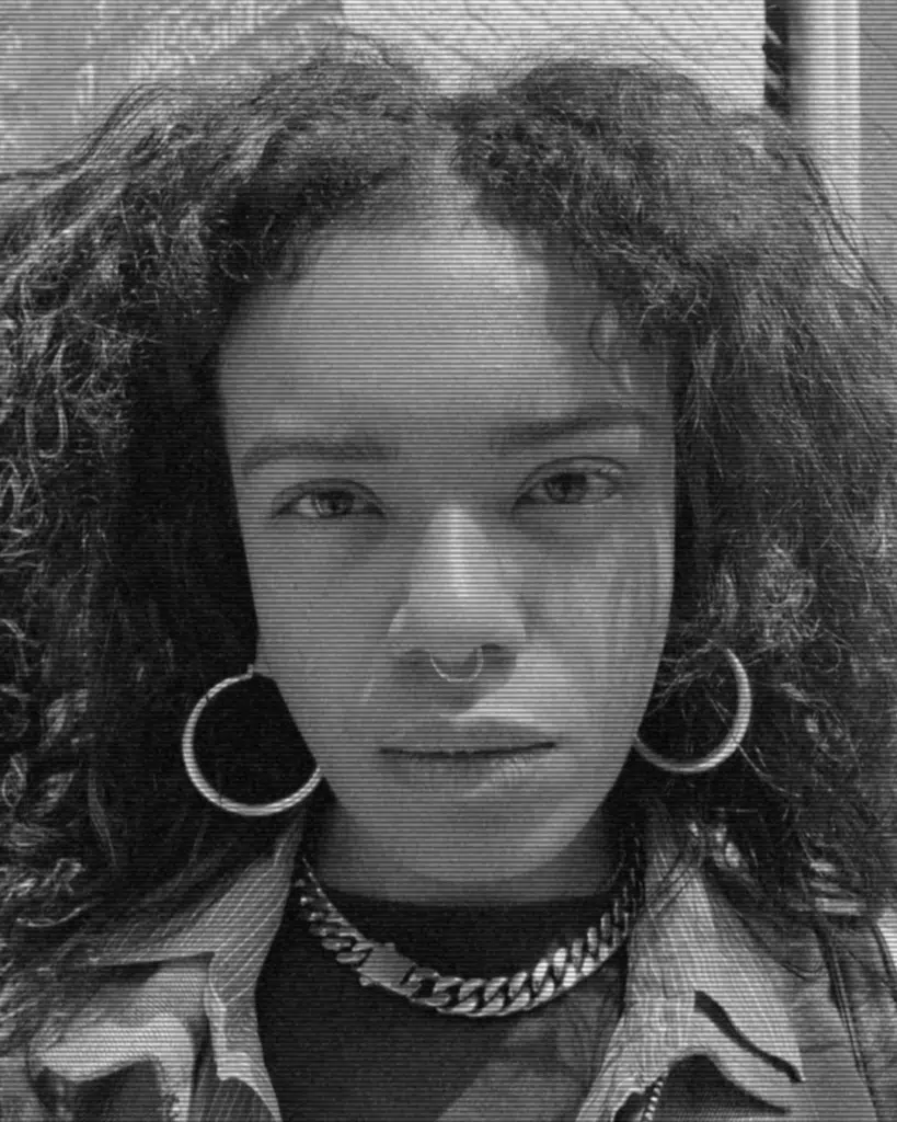 A black and white photo of a woman with curly hair.