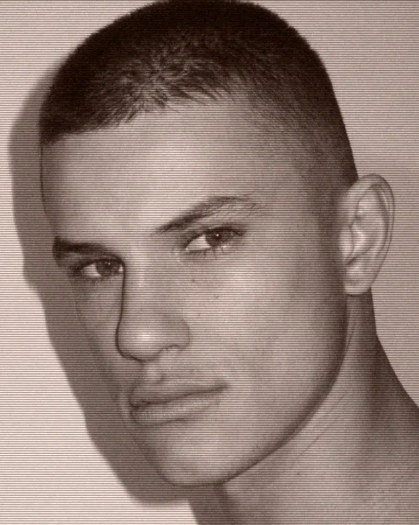 A man with a shaved head and short hair.