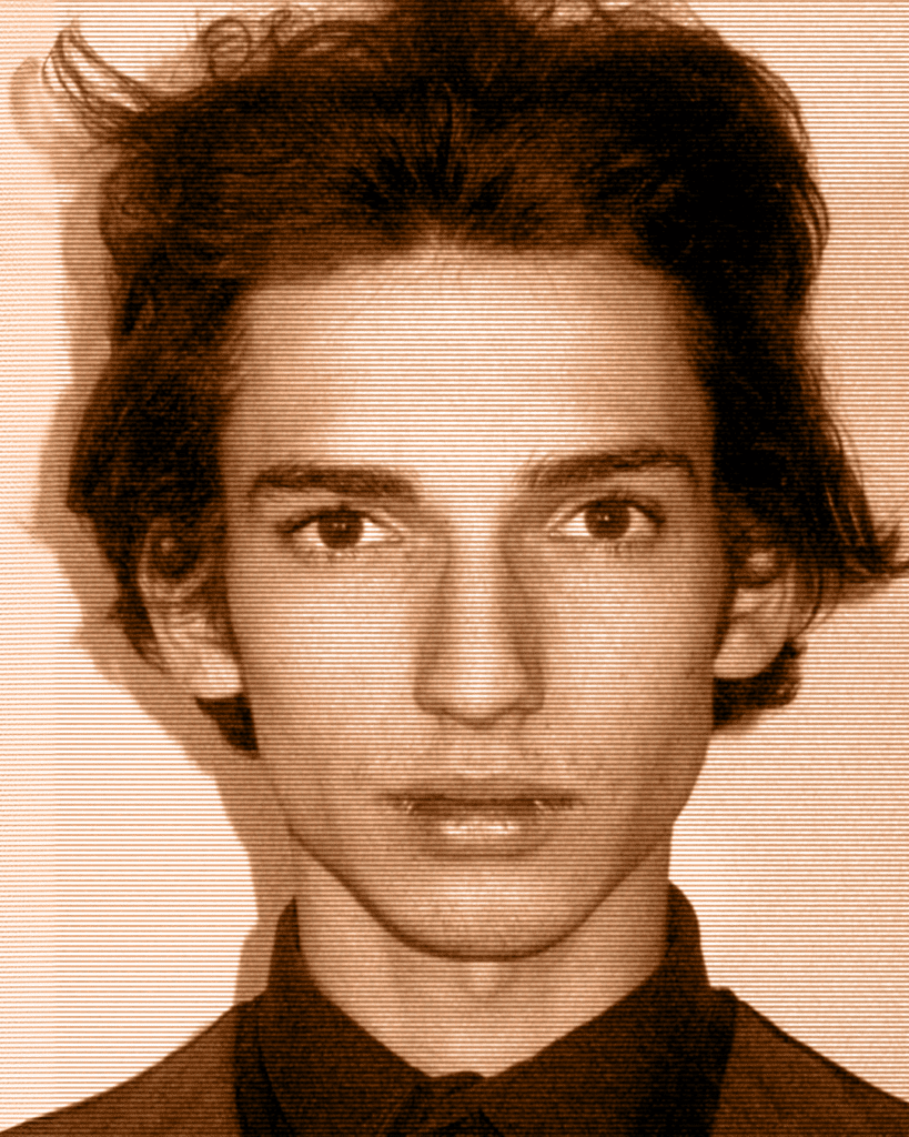 A man with long hair and a black shirt.