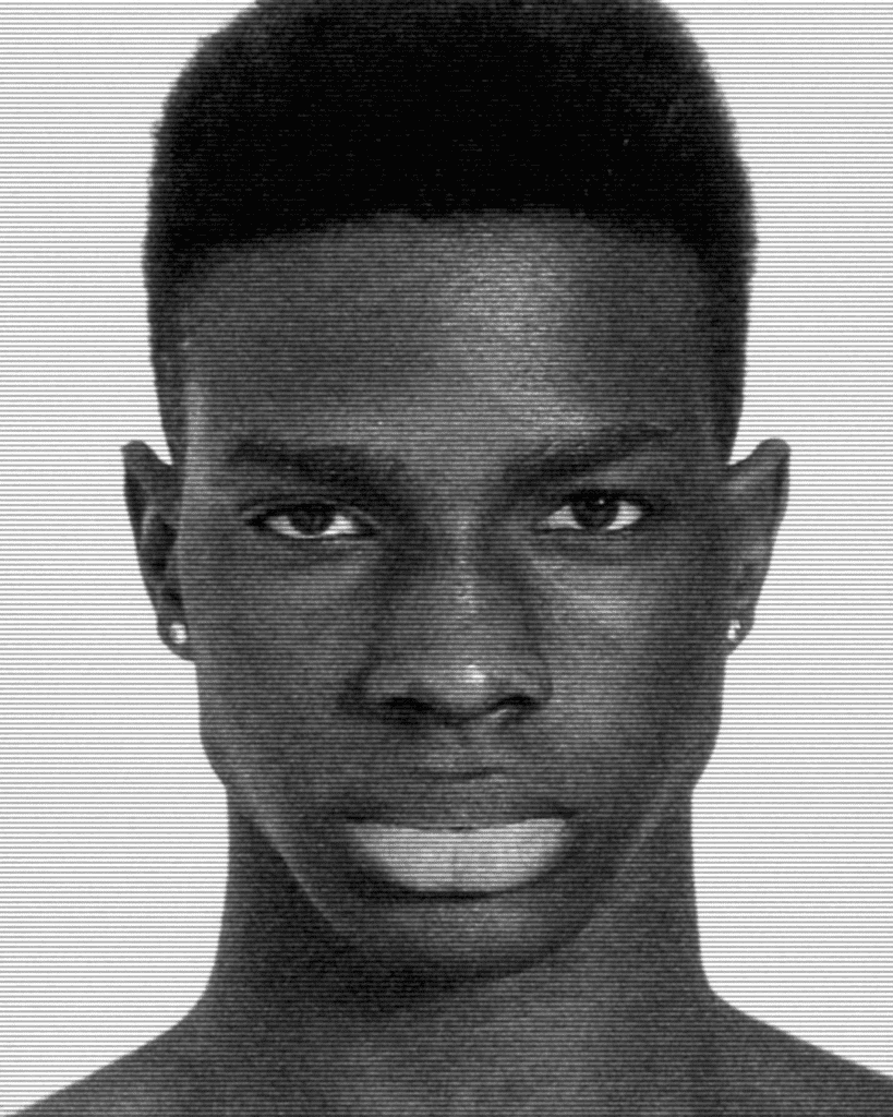 A black and white photo of a man with a very short haircut.