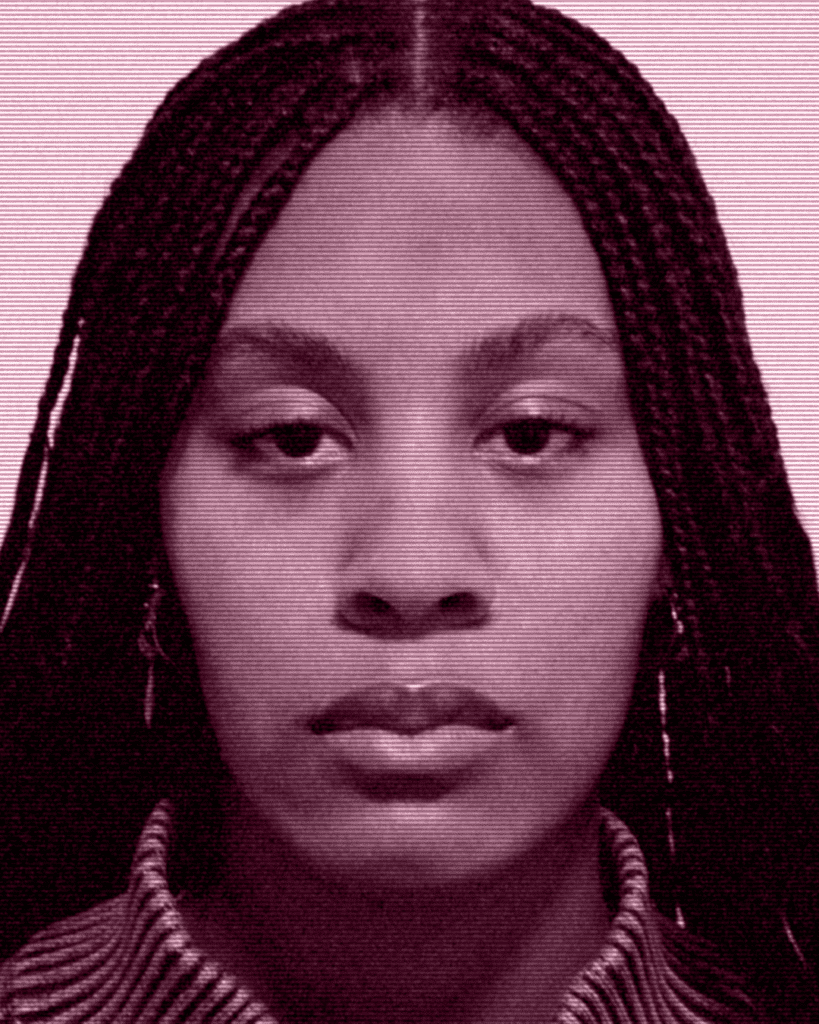A woman with long braids is looking at the camera.