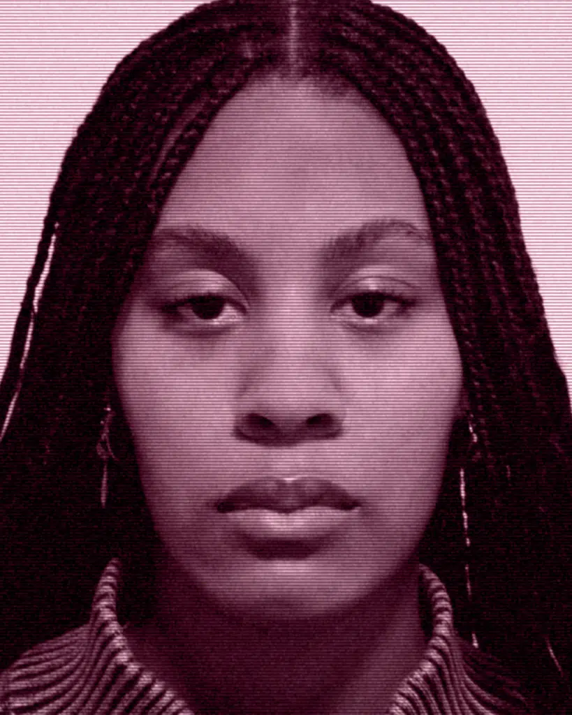 A woman with long braids is looking at the camera.