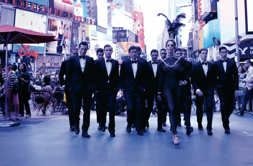 A group of men in tuxedos walking down the street.