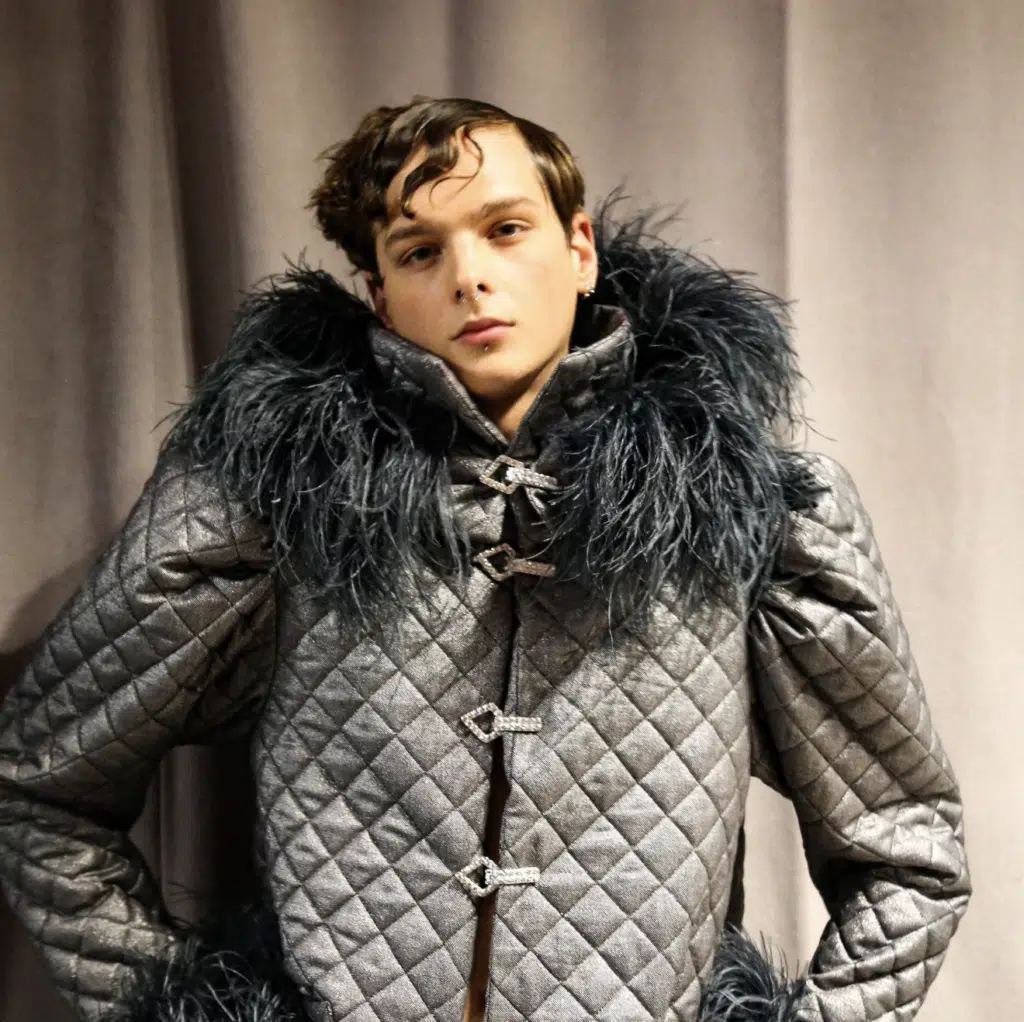 A man in a silver jacket with fur.