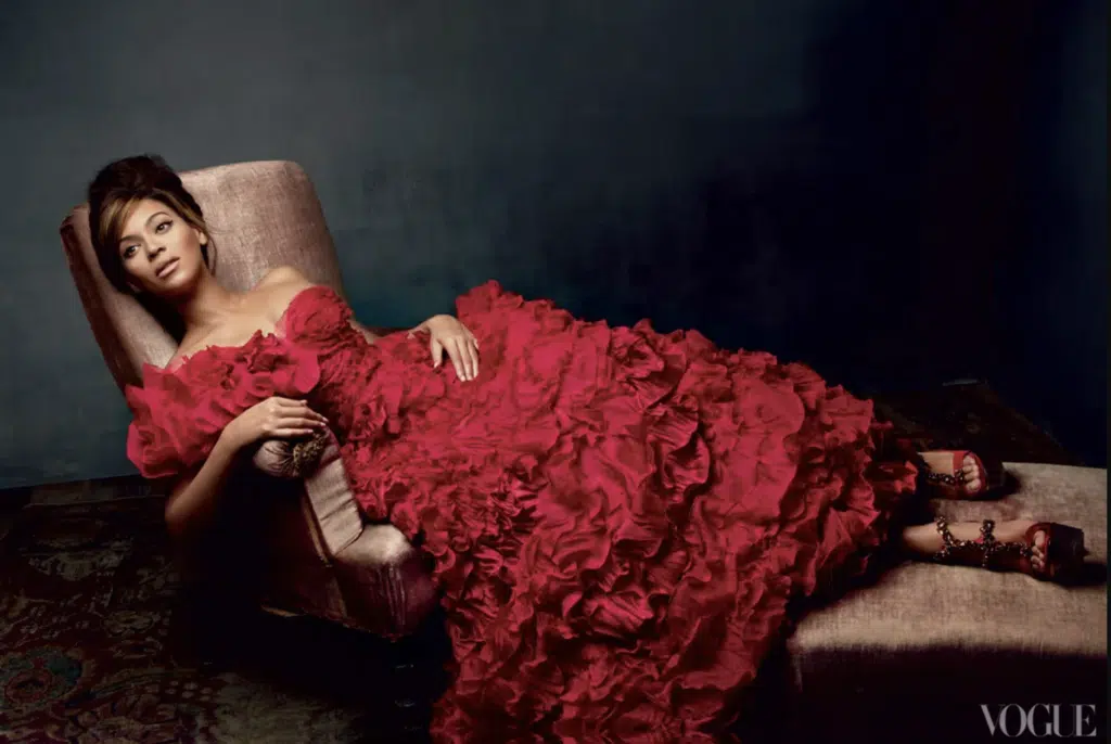 A woman in red dress laying on a couch.