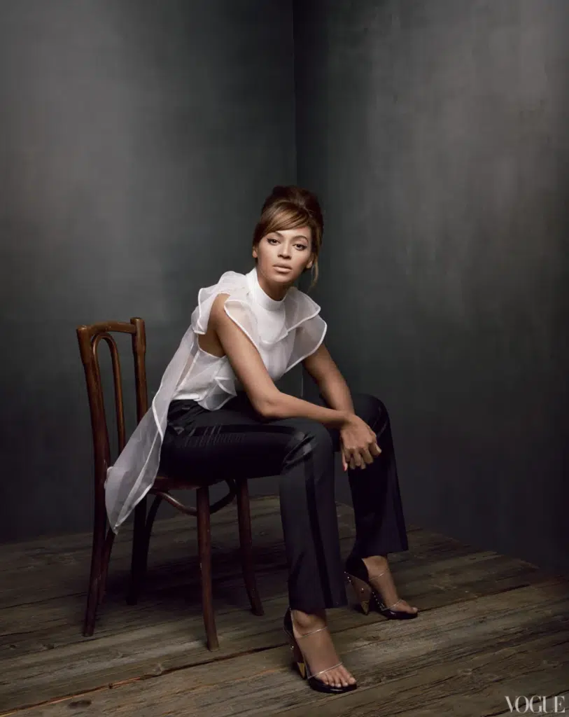 A woman sitting on top of a wooden chair.