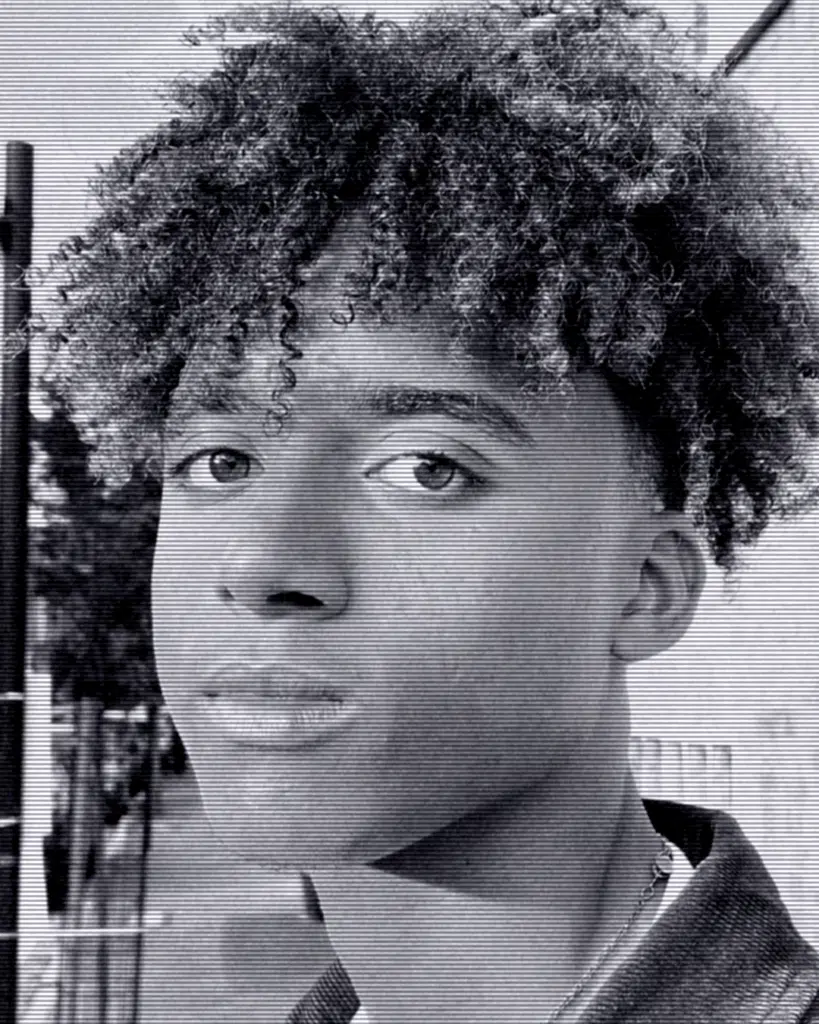 A young man with a curly hair style.