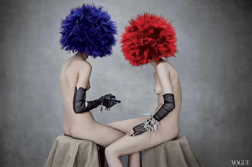 Two women with blue and red wigs sitting next to each other.