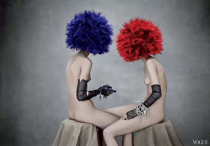 Two women with blue and red wigs sitting next to each other.