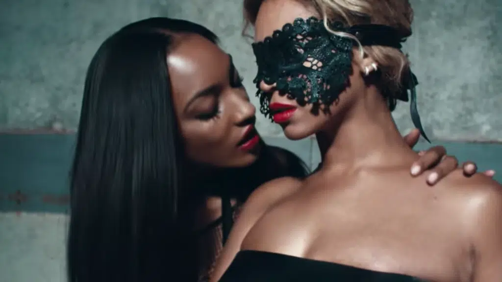 Two women in black lingerie and a mask